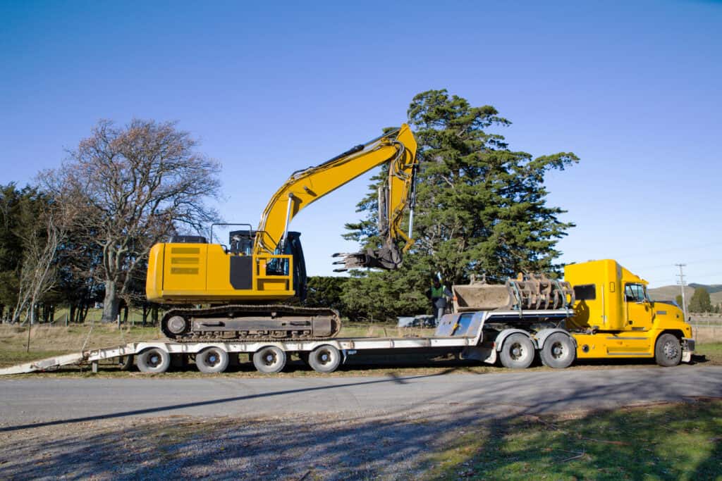 Yellow excavator on trailer