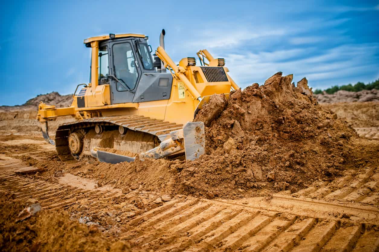 Excavator working with earth and sand in sandpit in highway