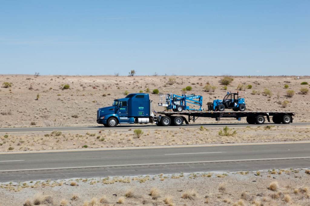 Semi-tractor pulling flatbed trailer 